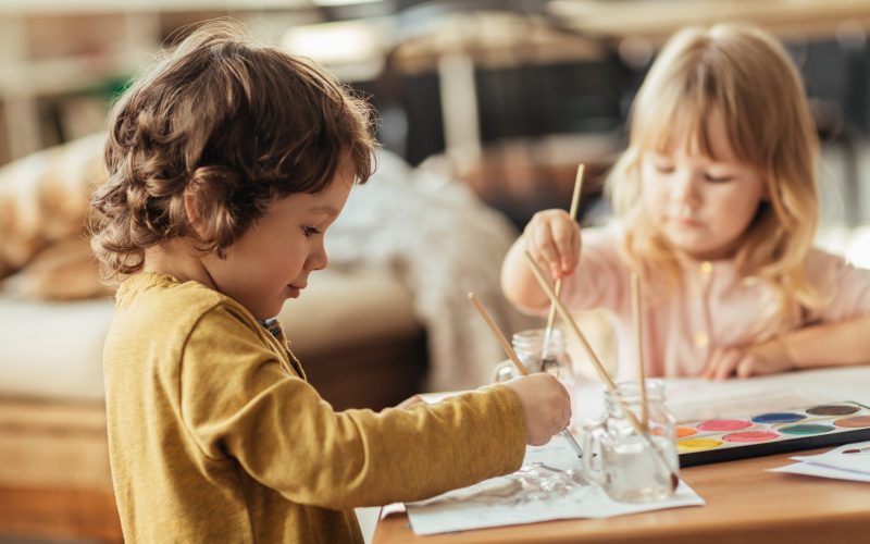 Close up of a brother and sister painting together